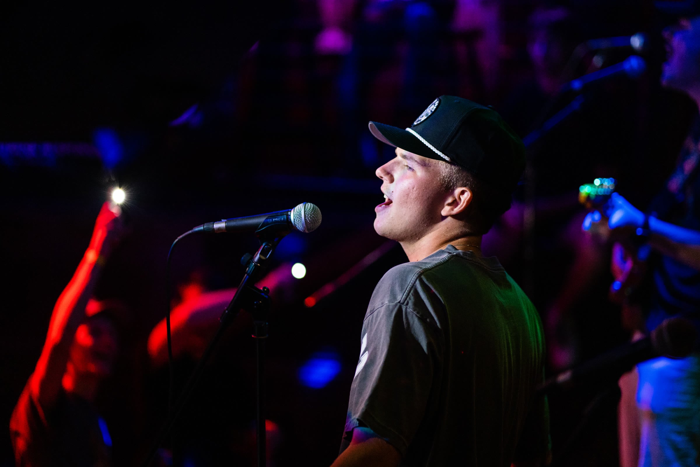 Singer performing on stage under colored stage lighting