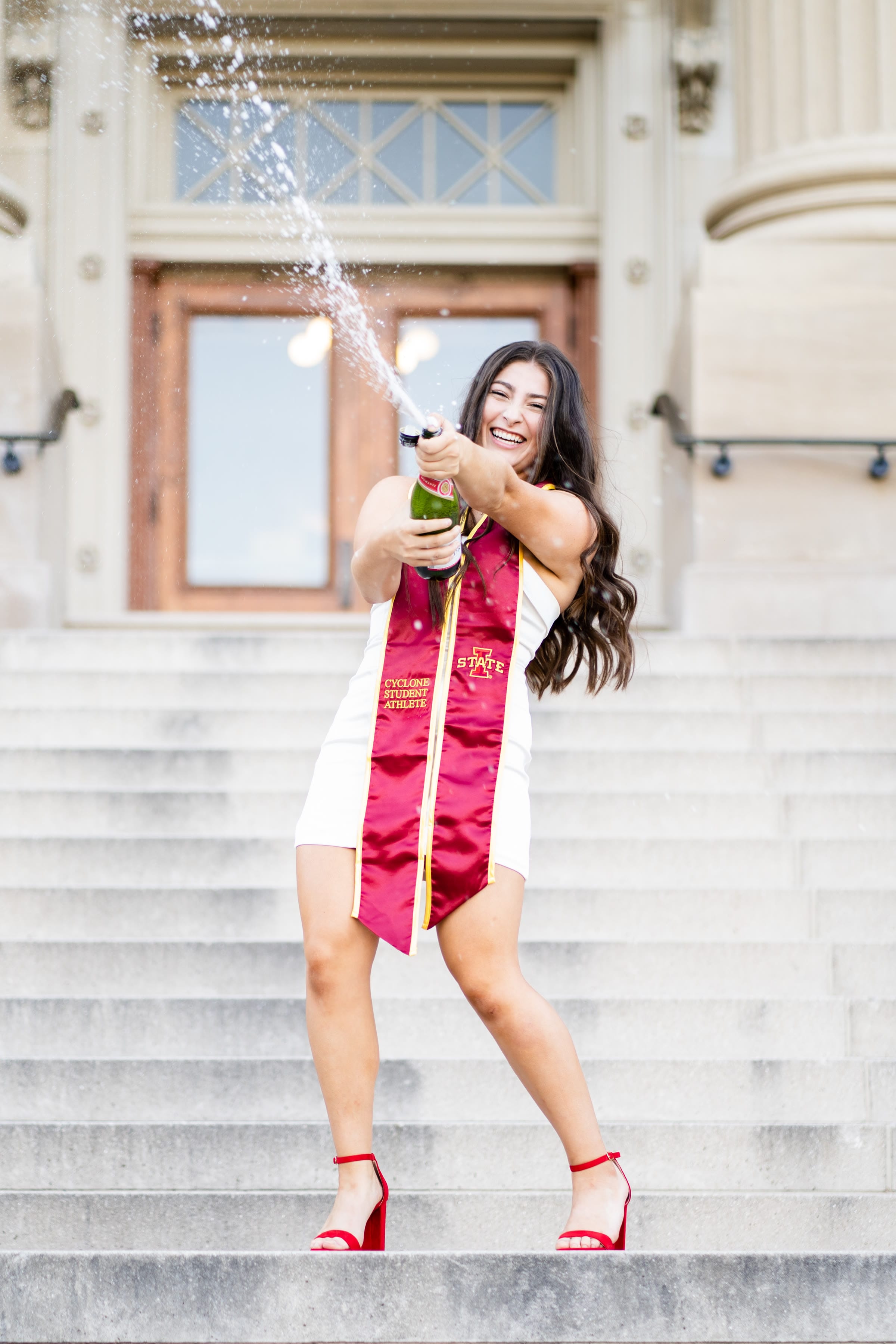 Graduate spraying a bottle of champagne in celebration