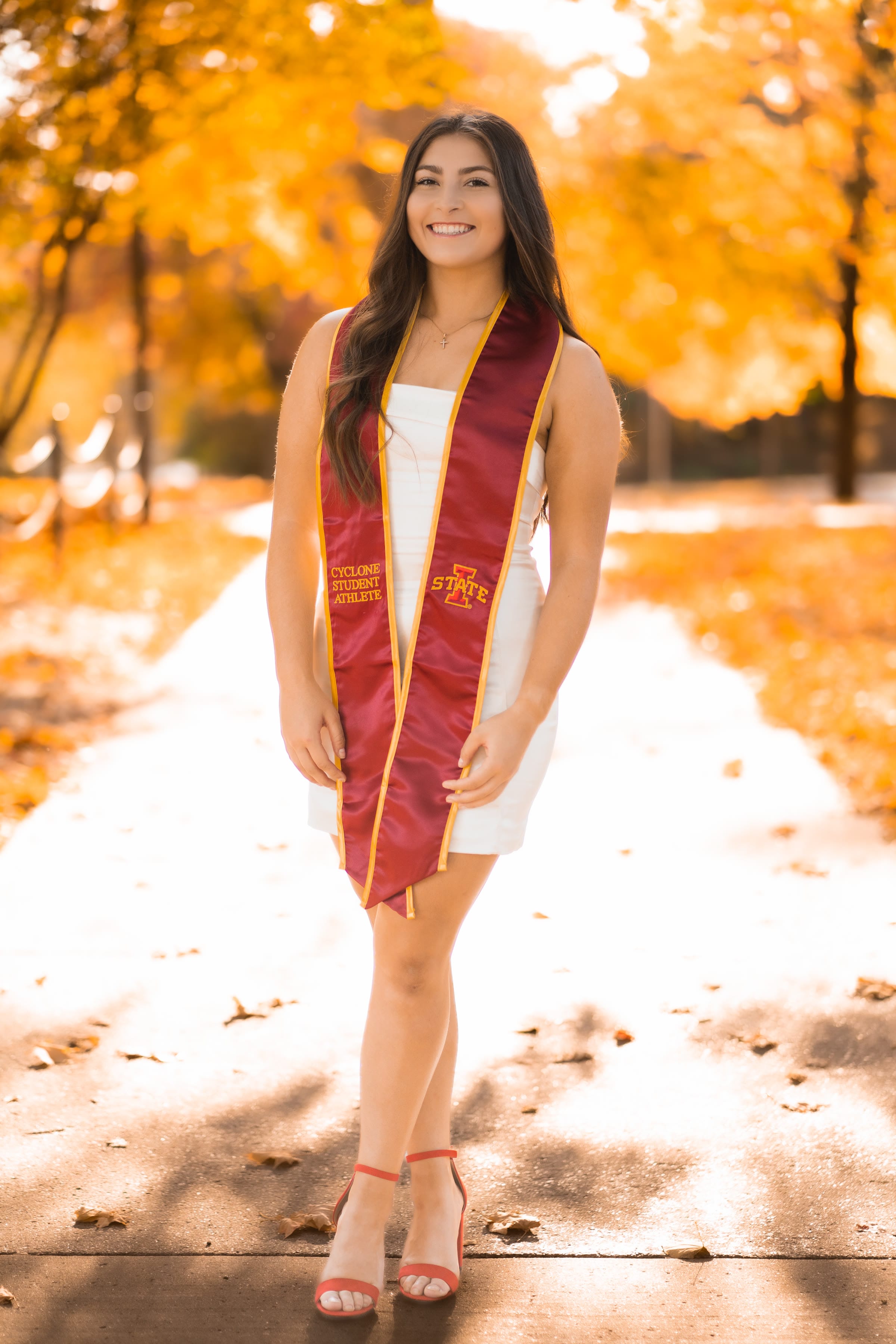Graduation portrait among fall foliage on the Iowa State campus
