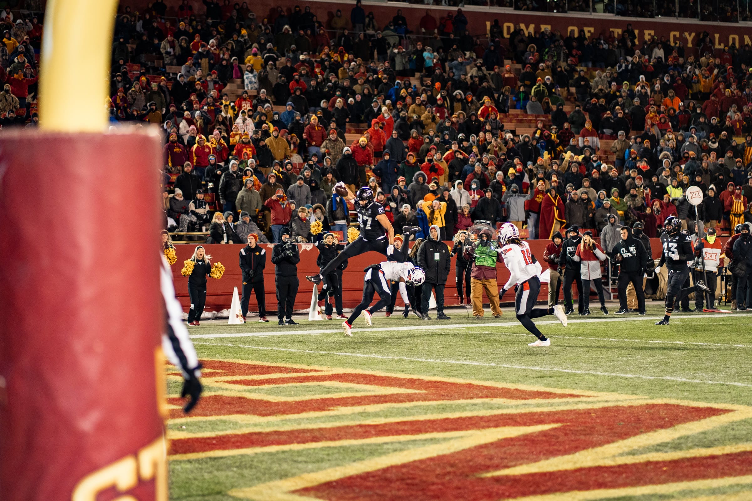 Football player leaping to make a touchdown catch in the end zone